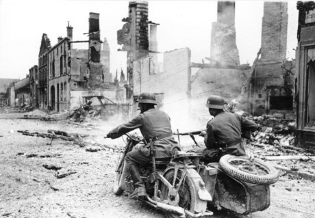 Lính Phát xít di chuyển qua một thị trấn của Pháp bị phá hủy nghiêm trọng năm 1940